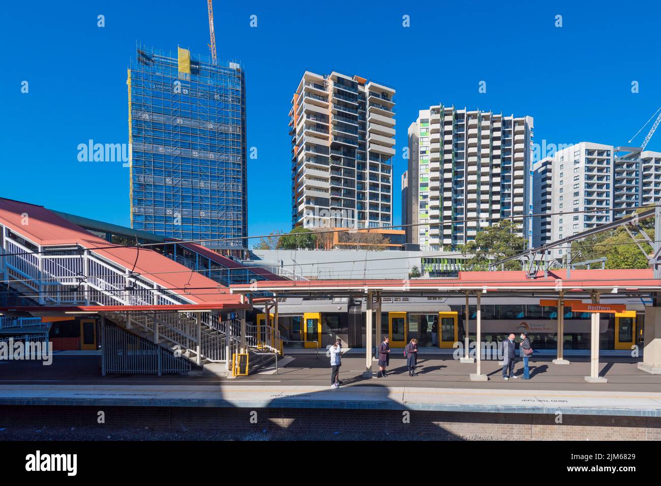 La plataforma de trenes y los nuevos bloques de apartamentos cerca de la estación de tren en el barrio interior de Sydney o Redfern, Nueva Gales del Sur, Australia Foto de stock