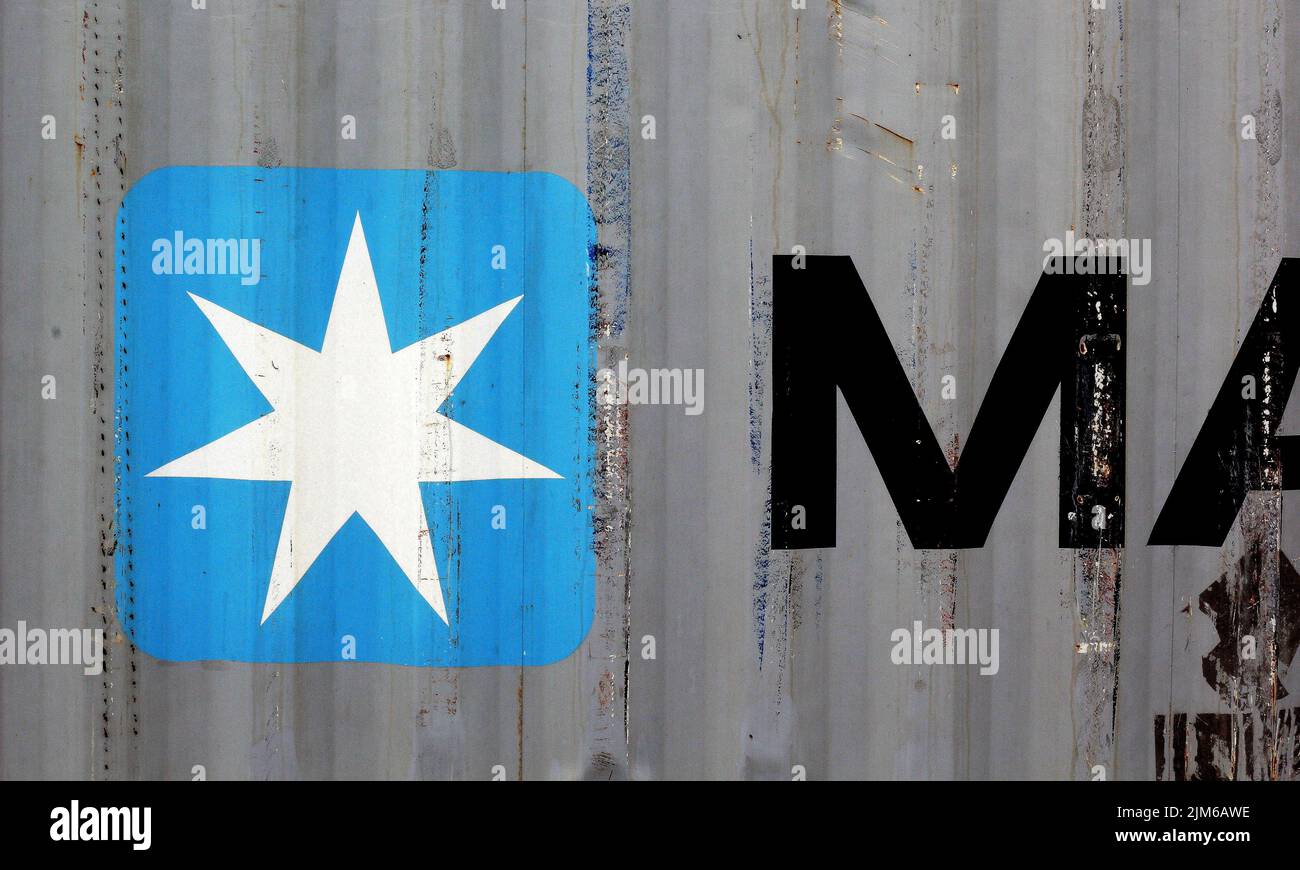 Es un contenedor gris con la inscripción Maersk en ita logotipo con una estrella sobre un fondo azul claro puede ser seenmaersk es una empresa de logística Foto de stock
