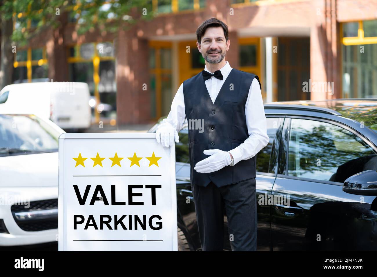 Servicio de valet parking. Hombre-conductor de pie Foto de stock