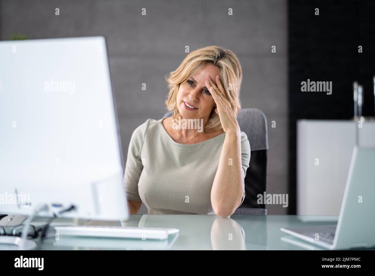 Dama cansada deprimida utilizando una computadora PC. Mujer molesta Foto de stock