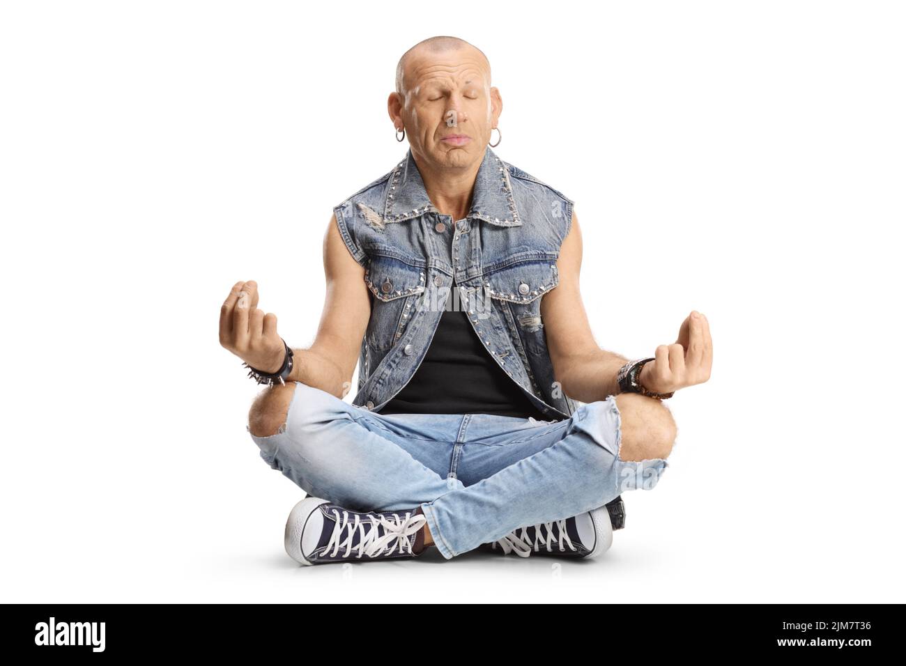 Hombre calvo sentado con las piernas arqueadas y practicando meditación aislada sobre fondo blanco Foto de stock
