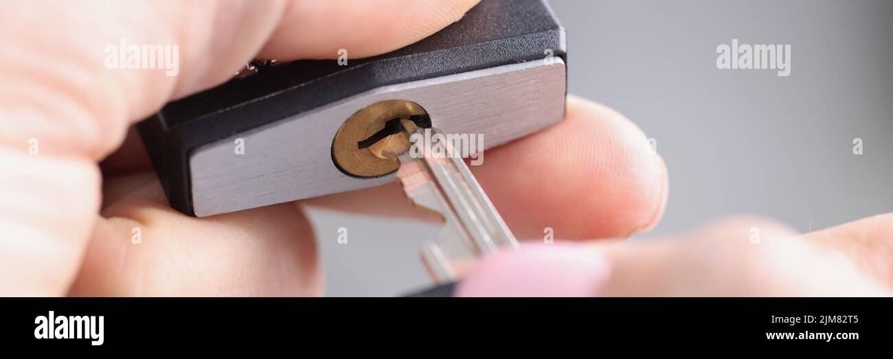 Dedos Insertando una llave en una cerradura metálica, borrosa Foto de stock