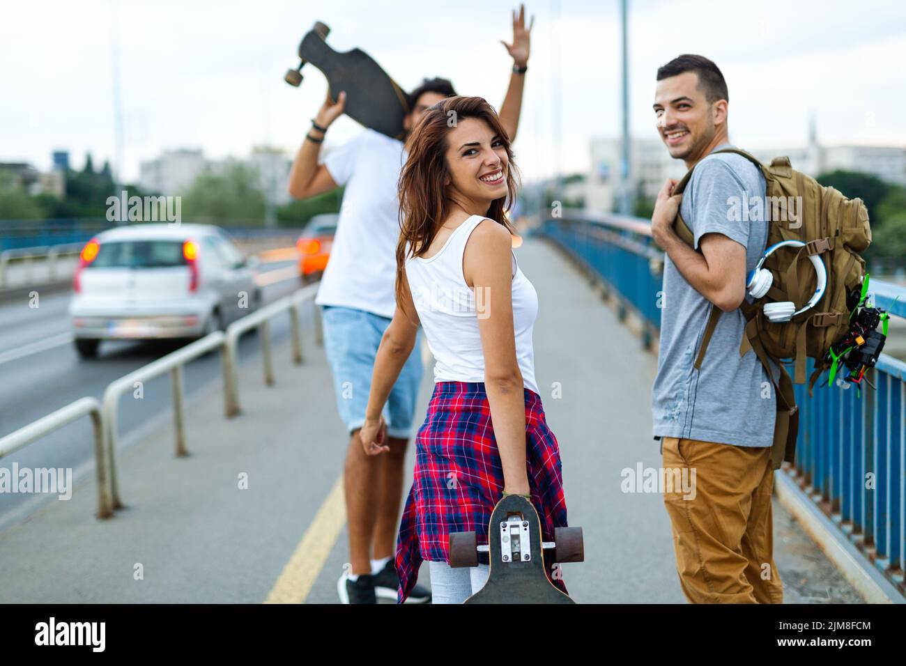 Un grupo de adolescentes felices pasan el rato juntos y disfrutan del skateboard al aire libre. Foto de stock