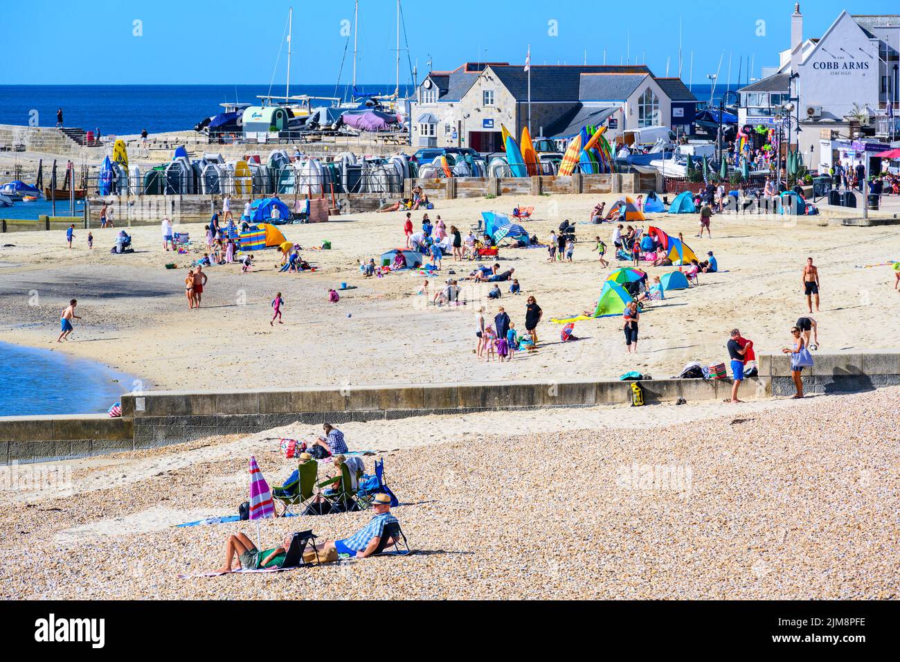 Lyme Regis, Dorset, Reino Unido. 5th de Ago de 2022. Clima en el Reino Unido: Los turistas disfrutan de una mañana relajante en la playa en el complejo costero de Lyme Regis mientras el cálido y soleado vuelve. Crédito: Celia McMahon/Alamy Live News Foto de stock