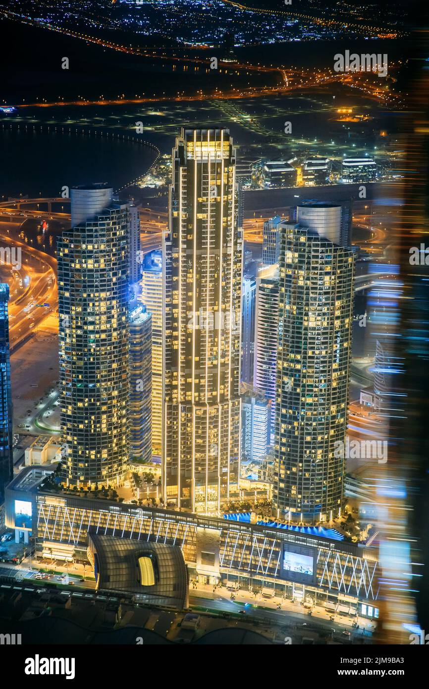 Resumen Bokeh borroso fondo de paisaje urbano iluminado con rascacielos en Dubai. Pasando por la moderna calle de la ciudad con iluminación. Urbano Foto de stock