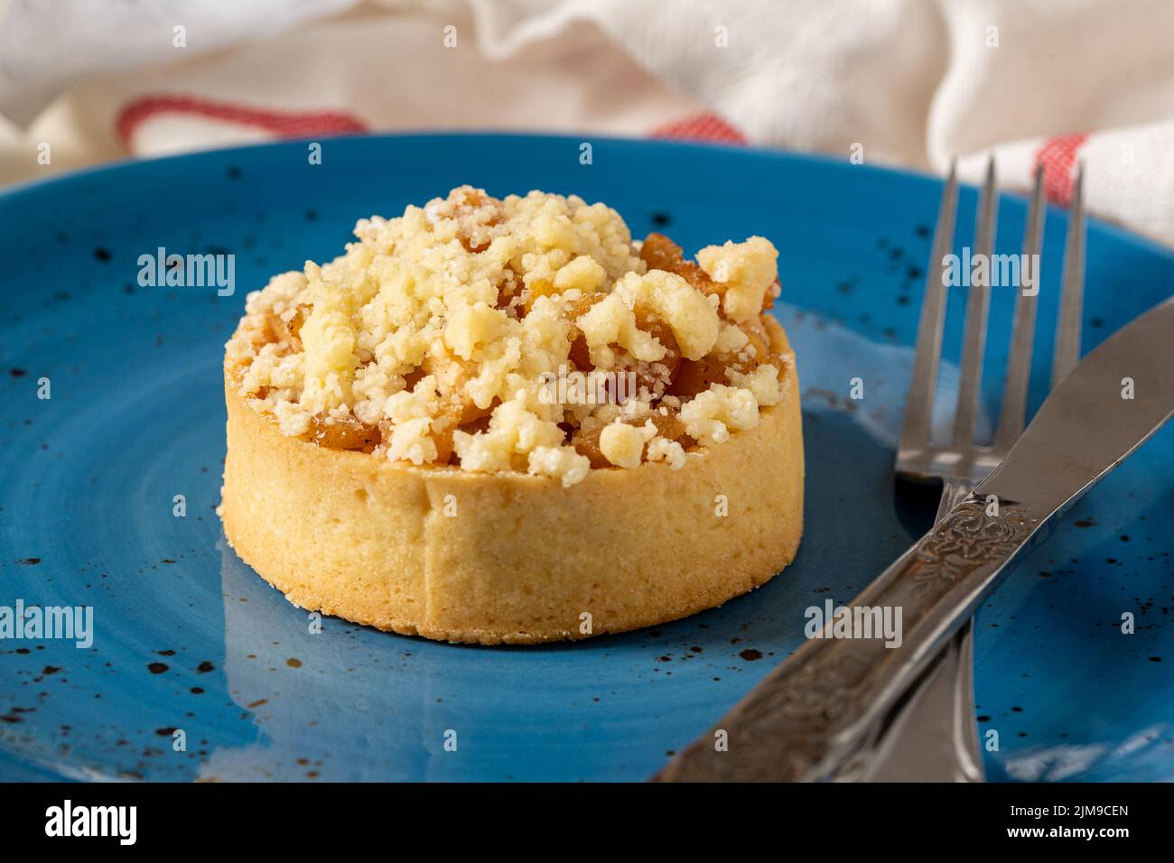 Pastel de manzana recién horneado en una porción en un plato de porcelana azul Foto de stock