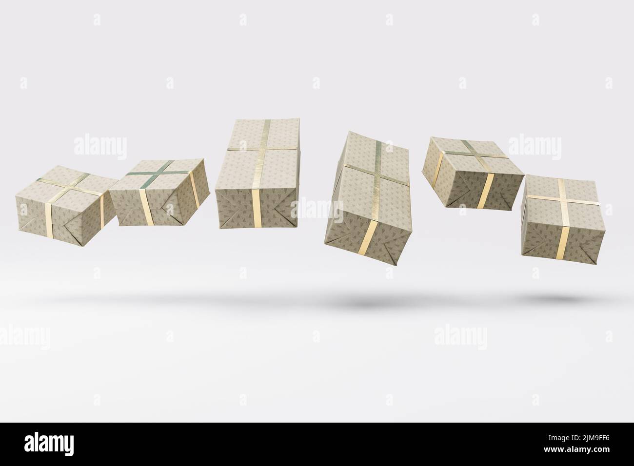 Una colección flotante de cajas de regalo rectangulares de diferentes tamaños envueltas en papel de regalo festivo con una cinta dorada sobre un studi aislado Foto de stock