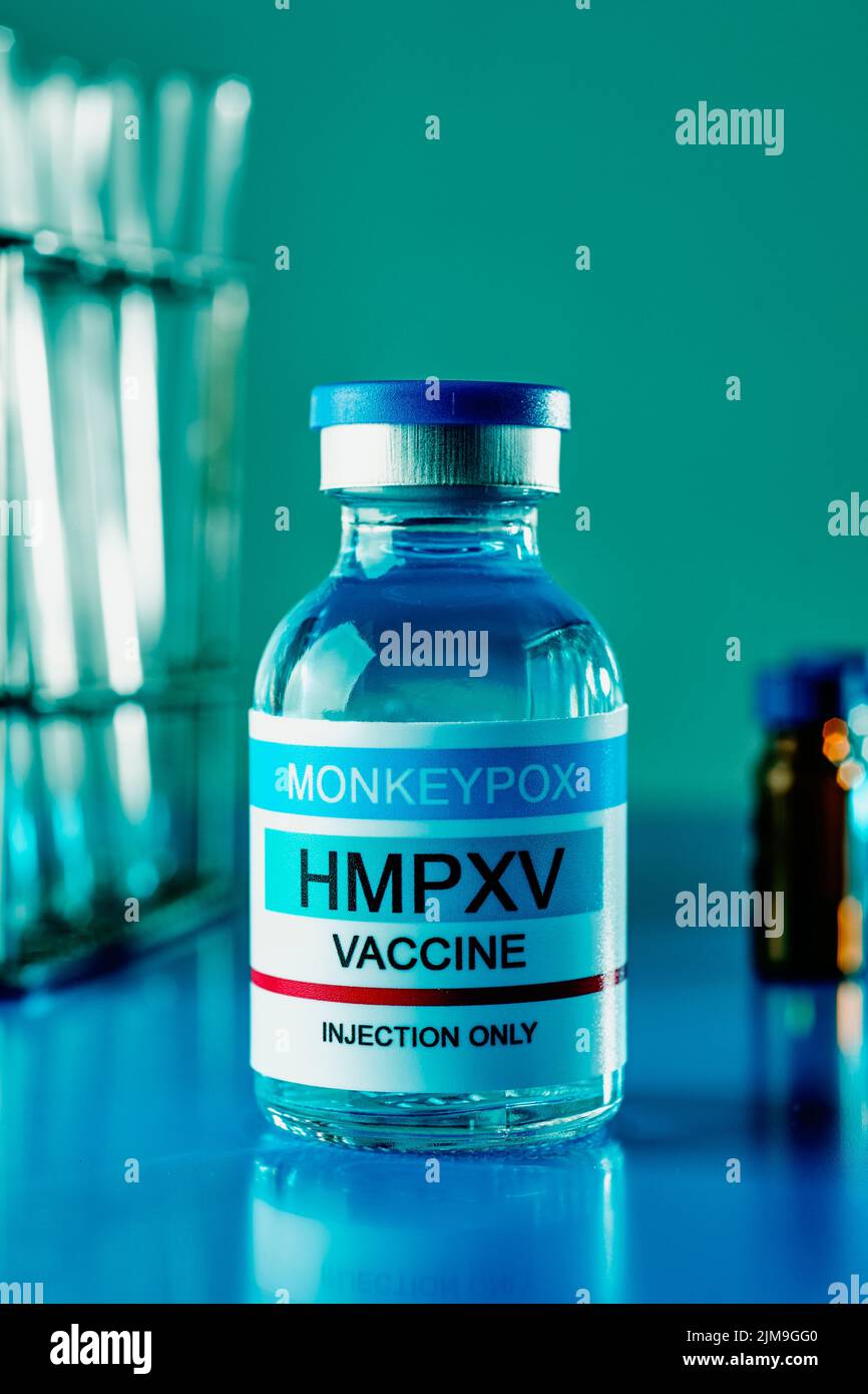 primer plano de un vial simulado de la vacuna contra la viruela del simio en una superficie azul en un laboratorio Foto de stock