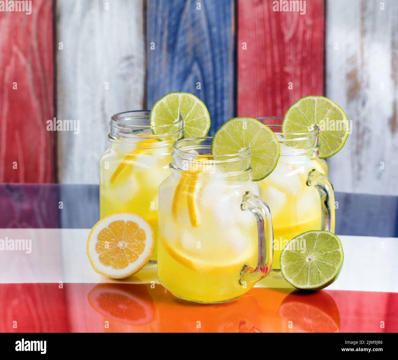 Tazas de vidrio llenas de limonada fría en los colores nacionales de EE.UU. Para la temporada de vacaciones Foto de stock