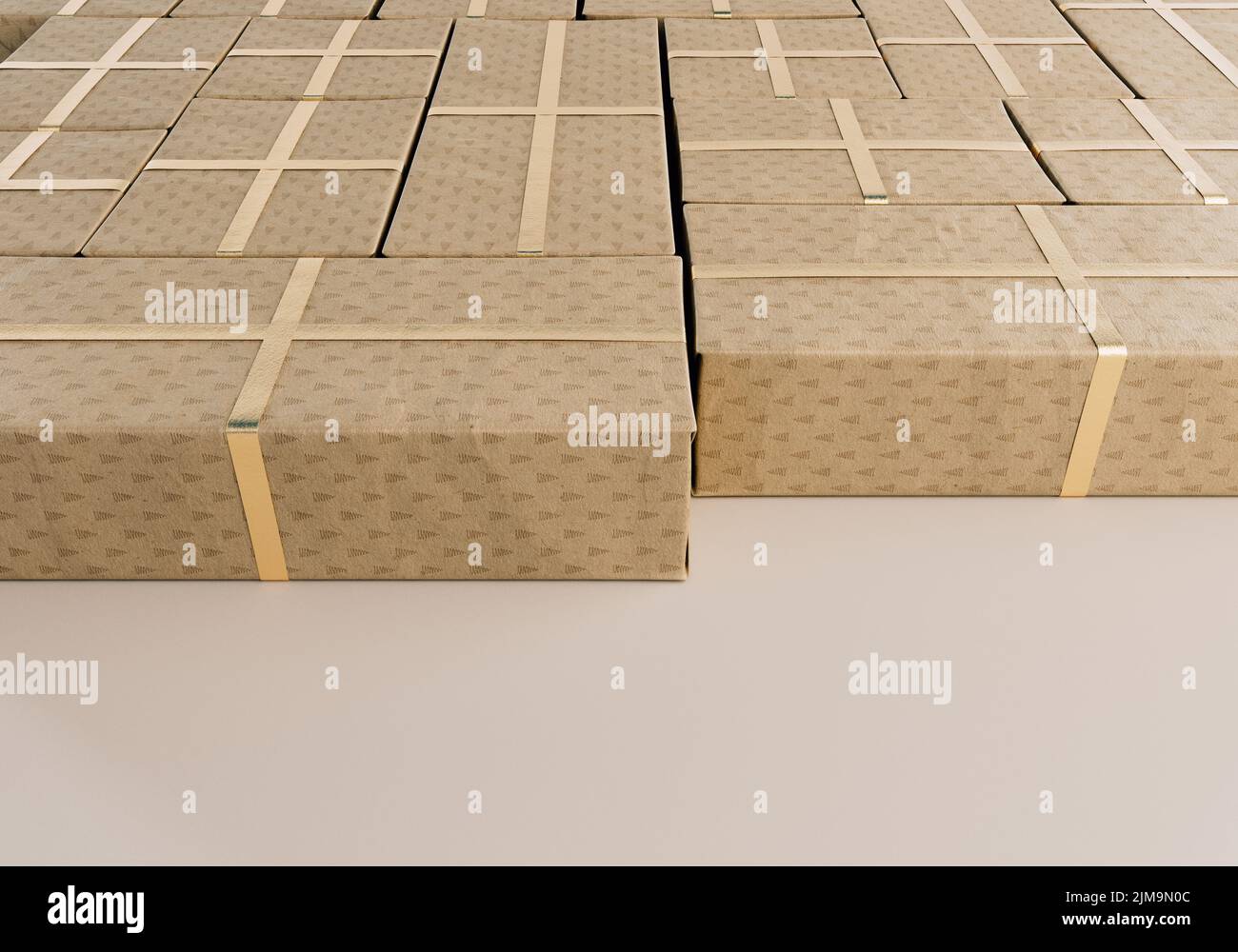 Una colección de cajas de regalo rectangulares de diferentes tamaños envueltas en papel de regalo de navidad con una cinta dorada colocada sobre una ba de estudio aislada Foto de stock