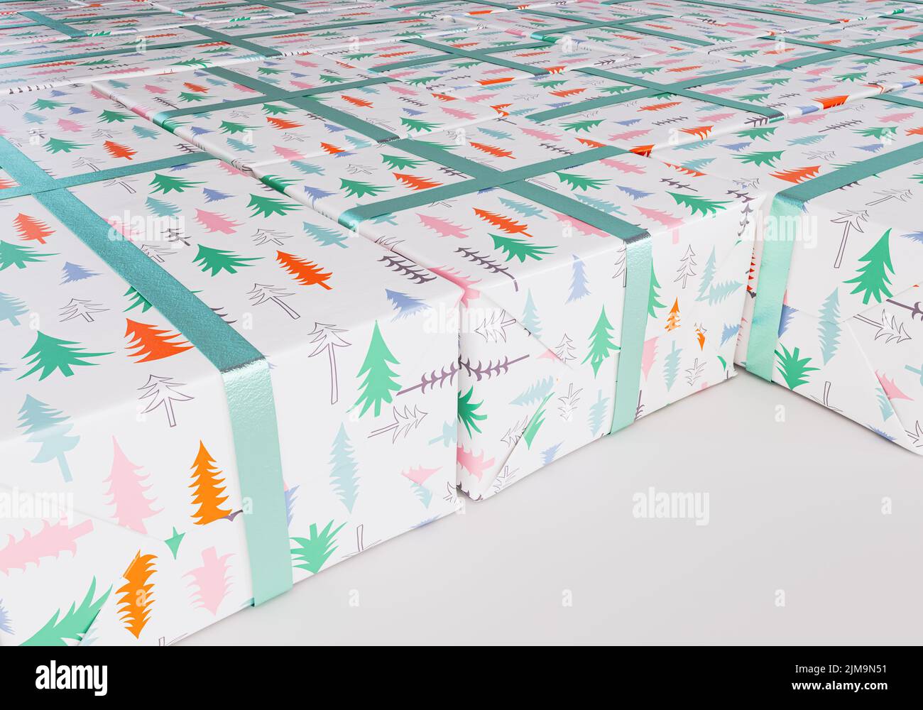 Una colección de cajas de regalo rectangulares de diferentes tamaños envueltas en papel de regalo de árbol de navidad con una cinta verde colocada plana sobre un espárrago aislado Foto de stock