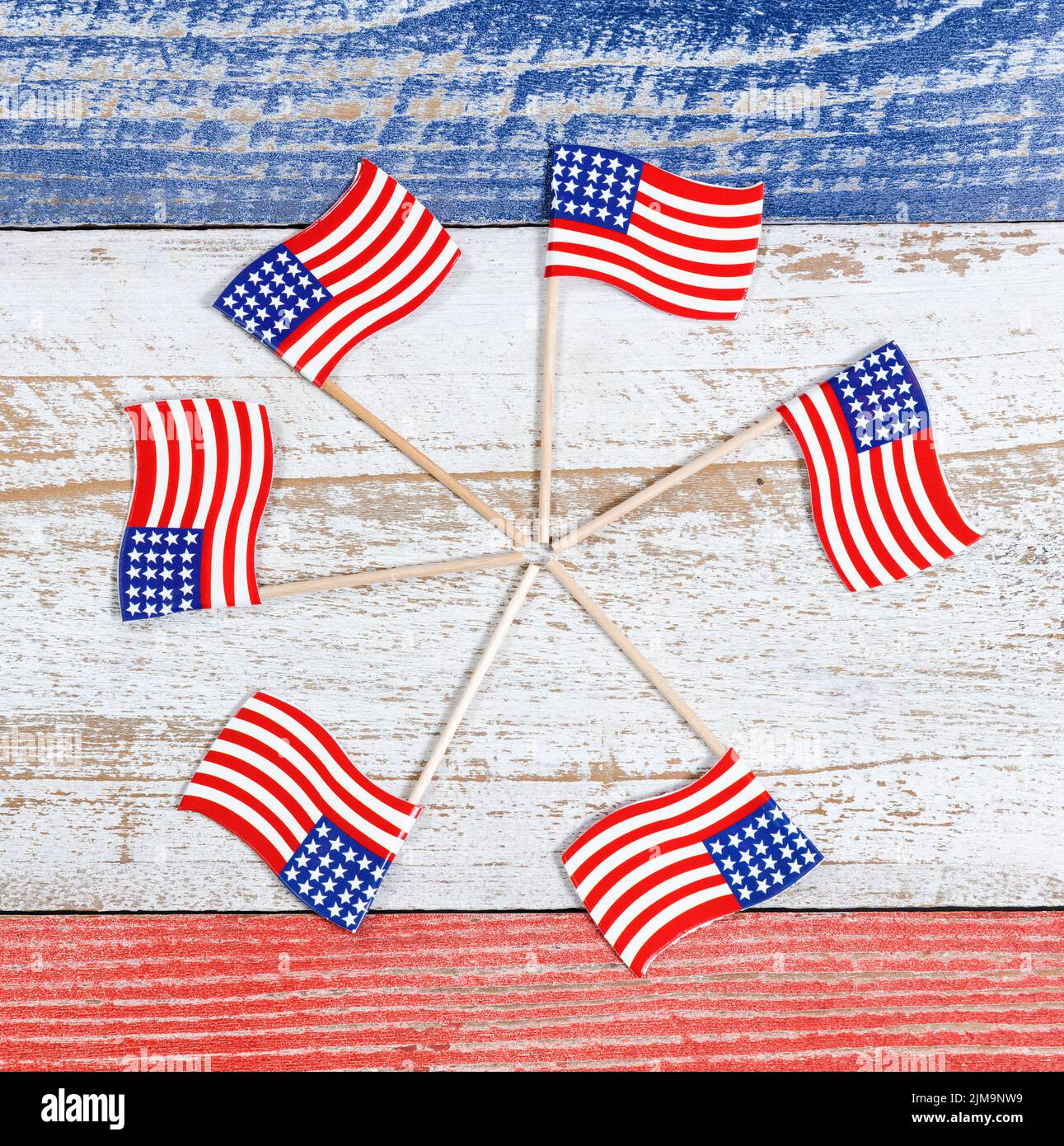 Pequeñas banderas de Estados Unidos en forma de rueda de alfiler sobre tablas rústicas con colores nacionales Foto de stock