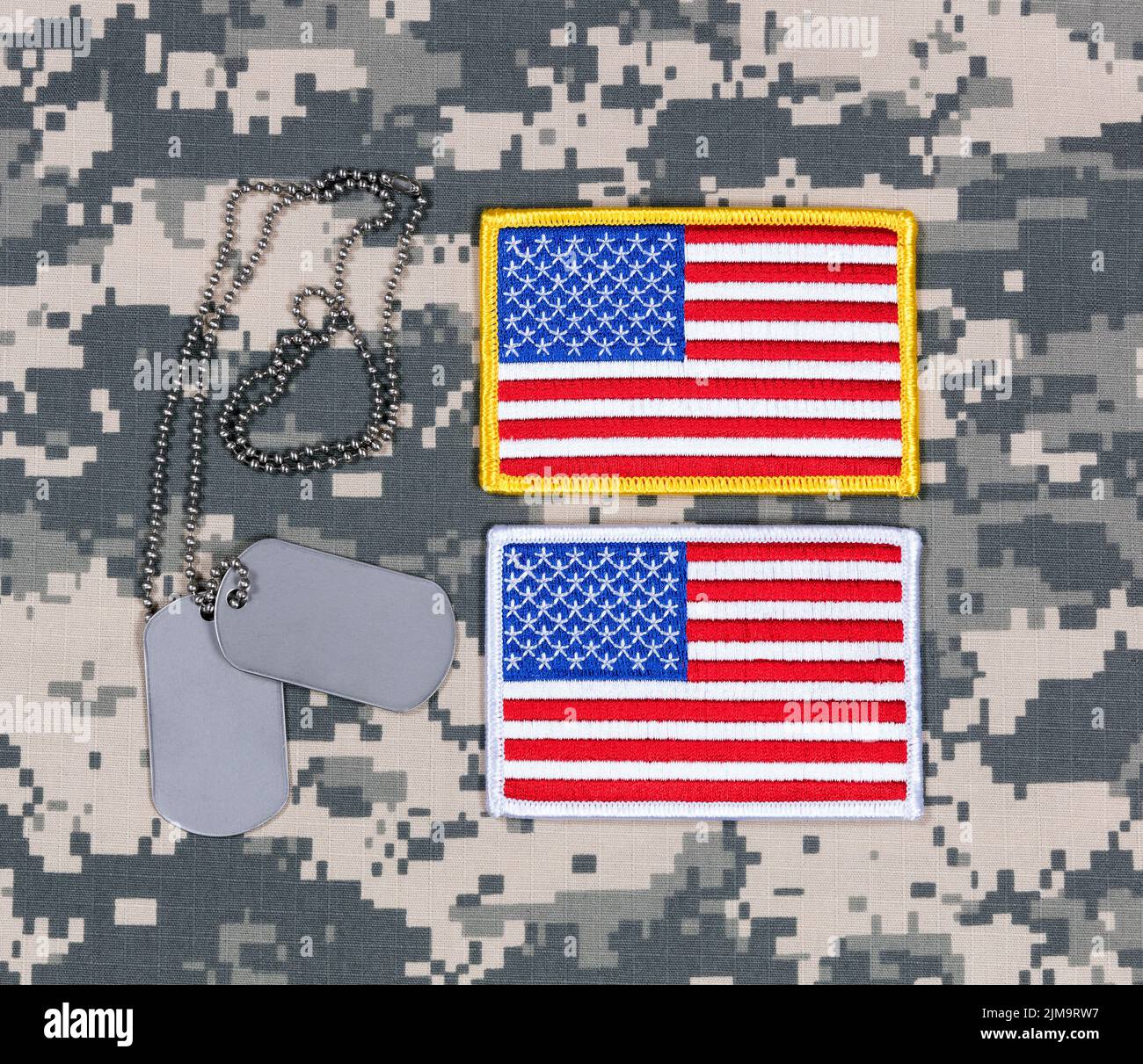Pequeños parches de bandera de EE.UU. Y etiquetas de identificación en uniforme militar de batalla Foto de stock