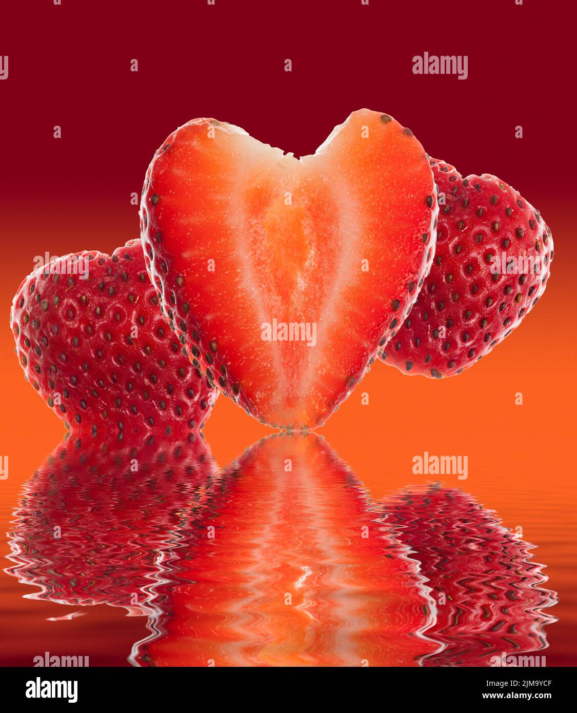 Fresa fresca cortada en forma de corazón reflejada Foto de stock