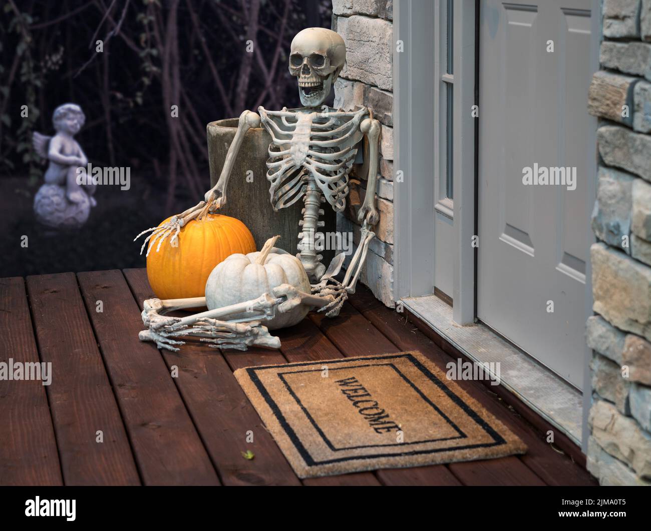 Esqueleto y calabazas en la puerta de Halloween Foto de stock