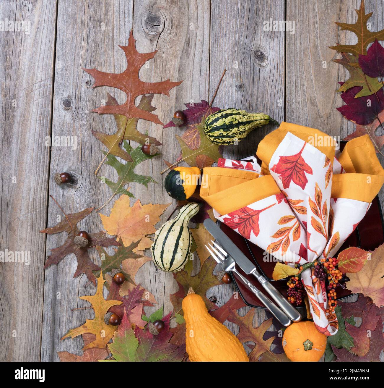 Cena para la temporada de otoño con decoración de calabaza y hojas sobre rústicas tablas de madera Foto de stock