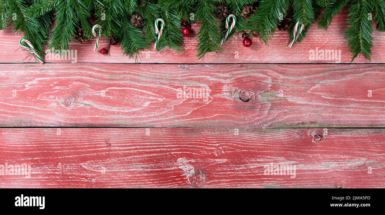 Rústicas tablas de madera roja con ramas de abeto para el concepto de la temporada navideña Foto de stock