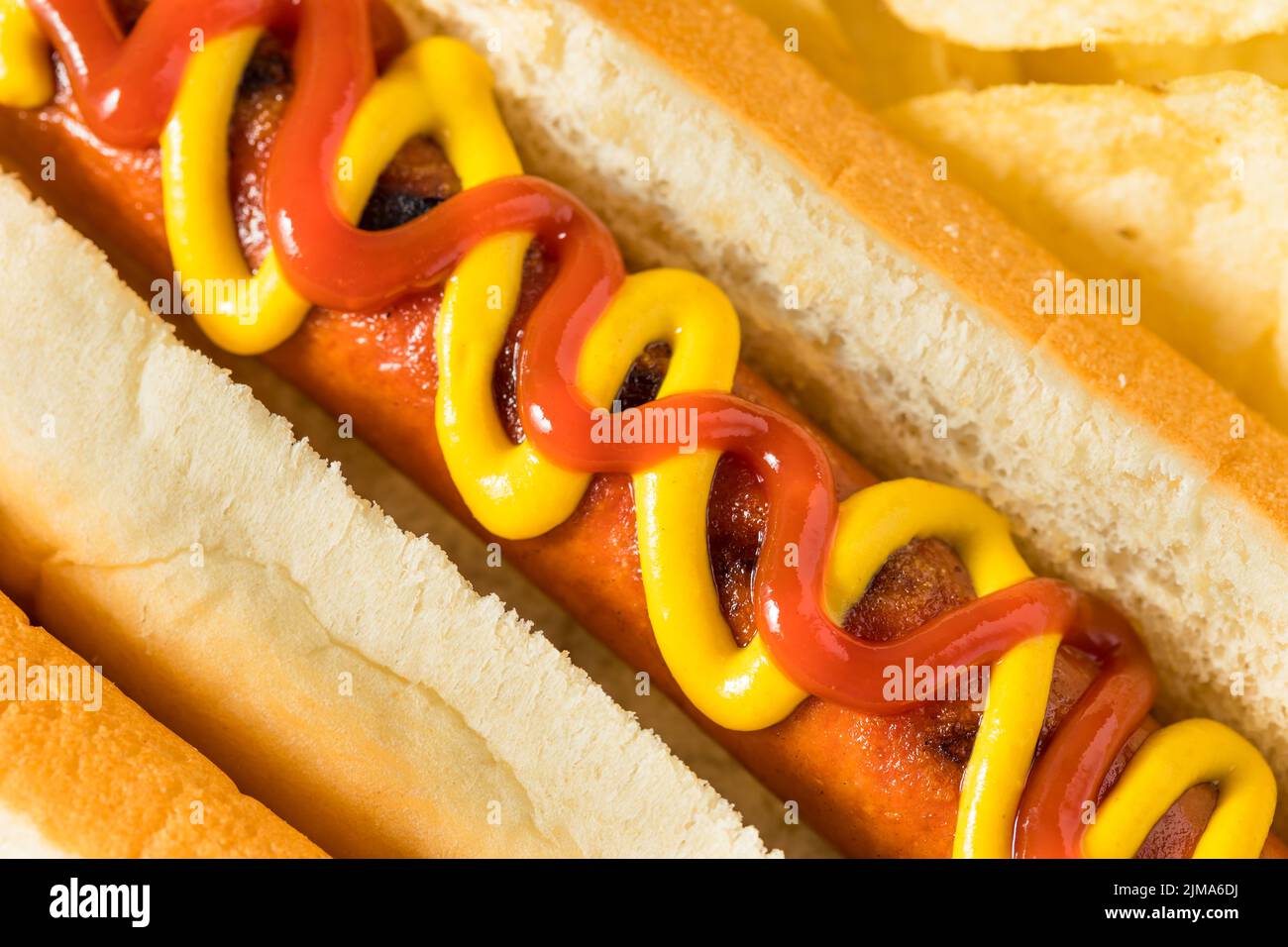 Perrito caliente casero con ketchup y mostaza con patatas fritas Foto de stock