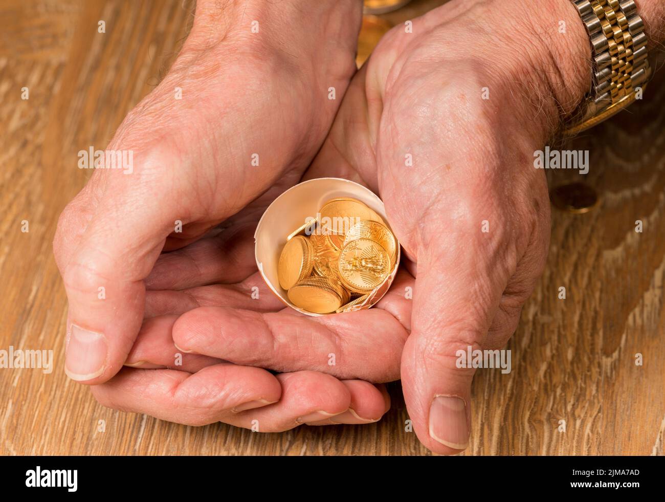 Monedas de oro puro en cáscara de huevo ilustrando el huevo del nido Foto de stock