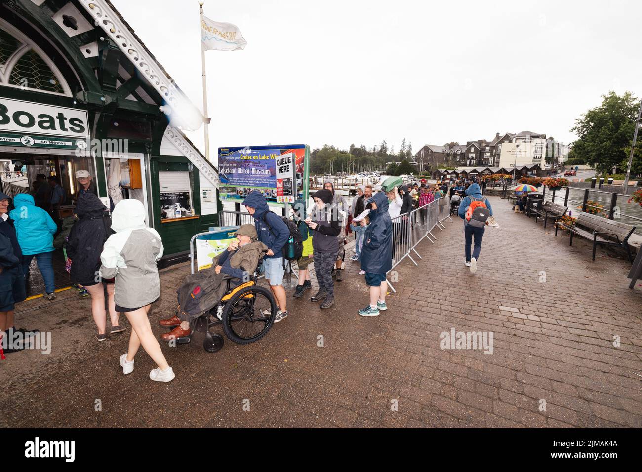 Lake District Cumbria 5th de agosto de 2022 UK.UK Weather Lake Windermere. Fuerte ducha de lluvia por la tarde durante media hora, pero los visitantes estaban listos con sus impermeables, todavía disfrutar de sus cruceros de vacaciones en el lago siempre popular ,. Crédito: Gordon Shoosmith/ Live News Foto de stock