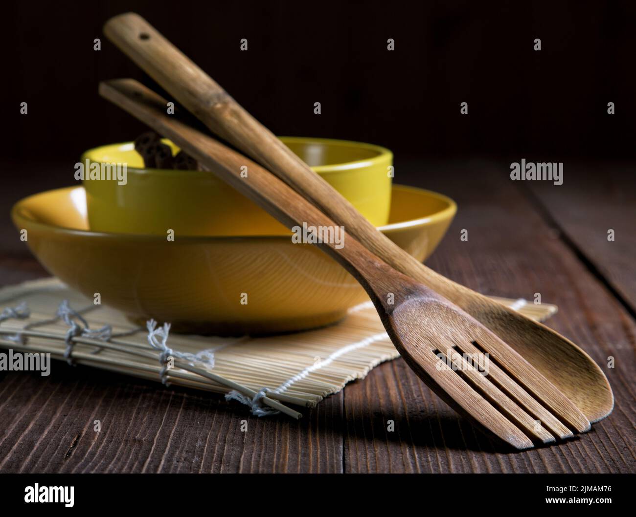 Bodegón con placas y espátulas para alimentos en una antigua tabla Foto de stock