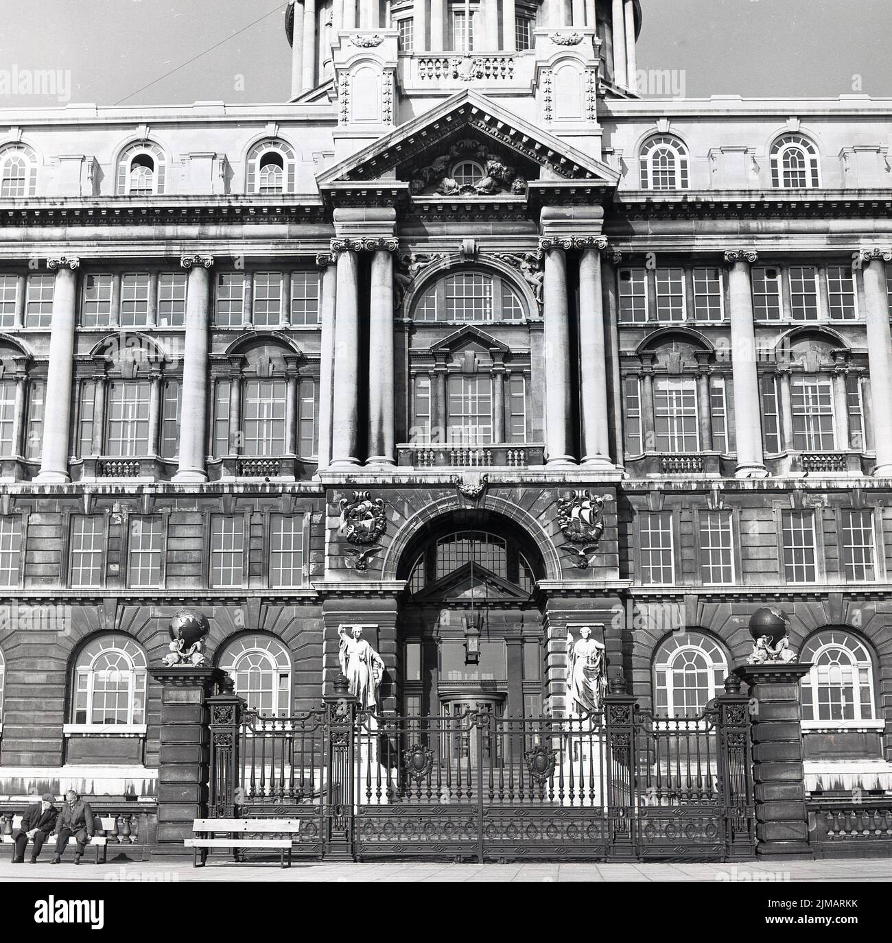 1960s, histórico, vista exterior del Liverpool Town Hall, Inglaterra, Reino Unido, dos hombres sentados en un banco fuera. Diseñado por John Wood, fue construido en 1749 y un ejemplo clásico de la arquitectura georgiana. Foto de stock