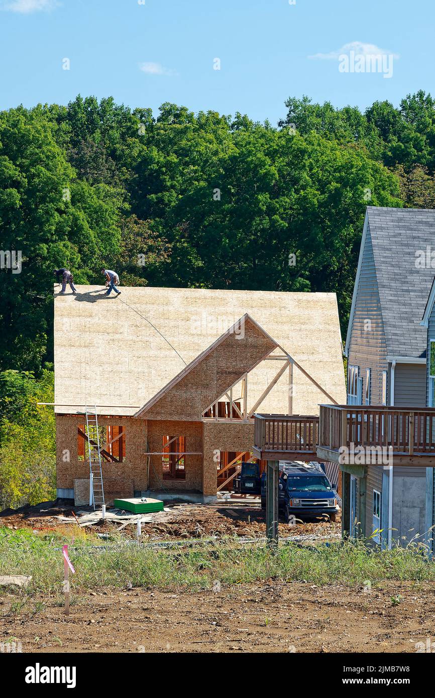 nueva construcción de la casa; 2 hombres que instalan el techo, casas terminadas, cubiertas, madera más allá, propiedades inmobiliarias, Industria; empleos, Pensilvania; Condado de Chester; PA Foto de stock