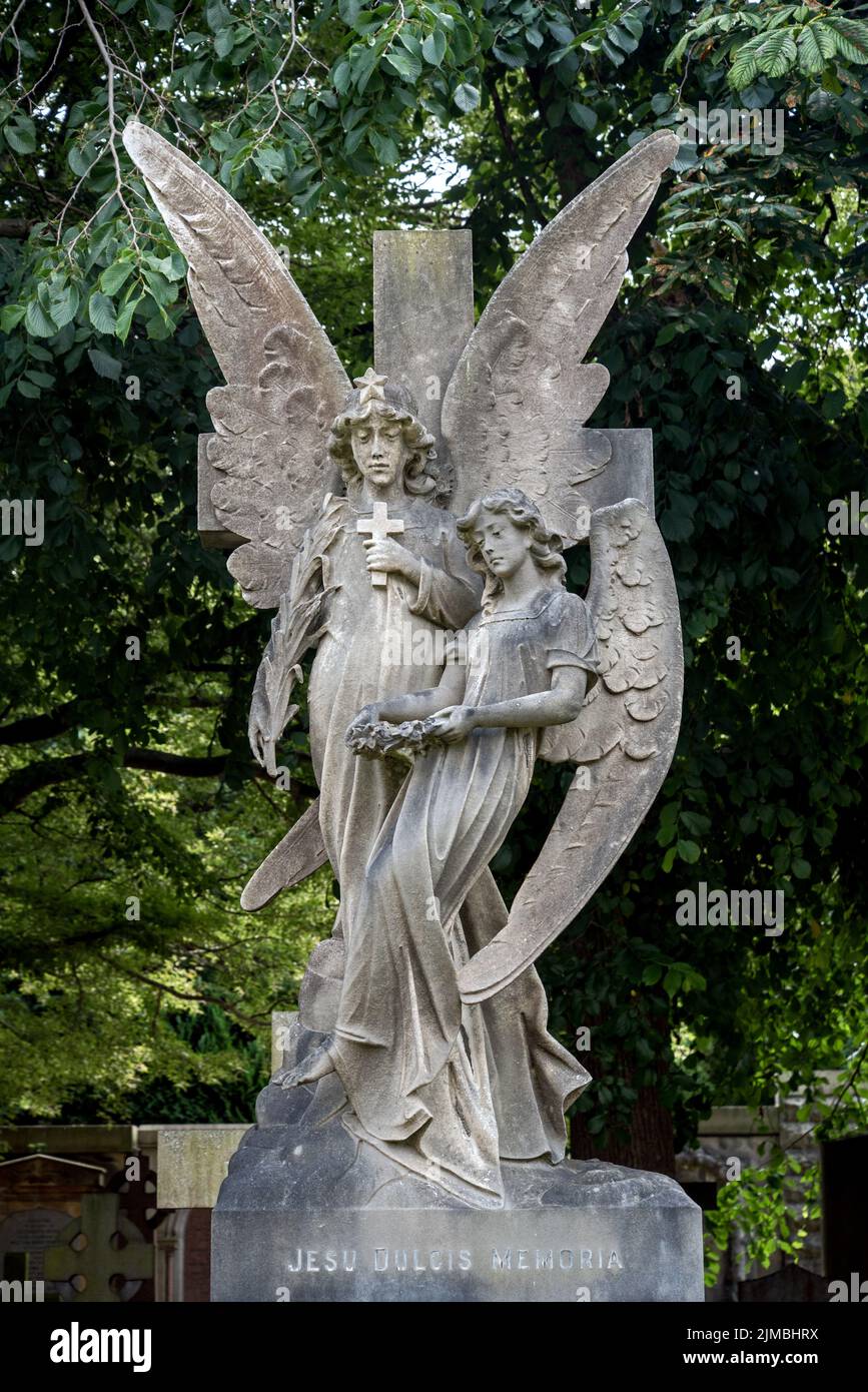 Monumento con dos ángeles, uno sosteniendo una cruz y el otro una corona en el Cementerio Dean de Edimburgo, Escocia, Reino Unido. Foto de stock
