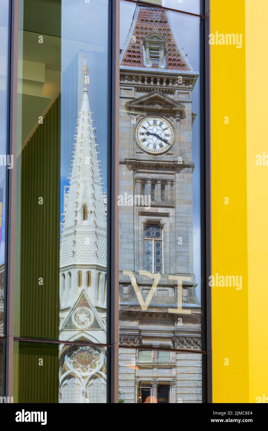 La torre del reloj en Chamberlain Square, Birmingham, Reino Unido, se refleja en un moderno edificio de vidrio cercano. 2022 Foto de stock