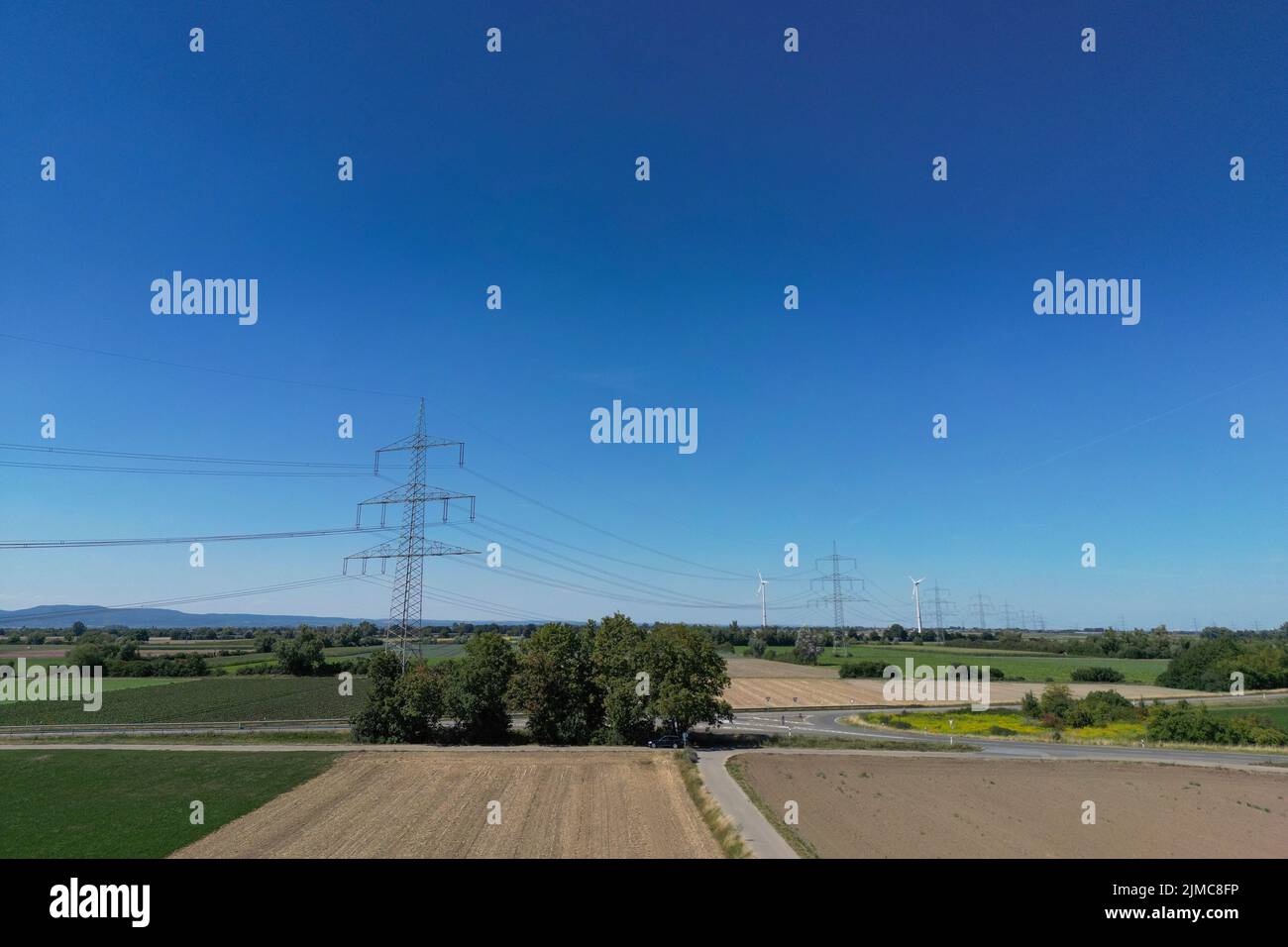 Energie, Deutschland, Rheinland-Pfalz, agosto de 03. Erhöhter Blick auf eine Überland Stromleitung mit Windkraft Anlagen im Hintergrund. Foto de stock