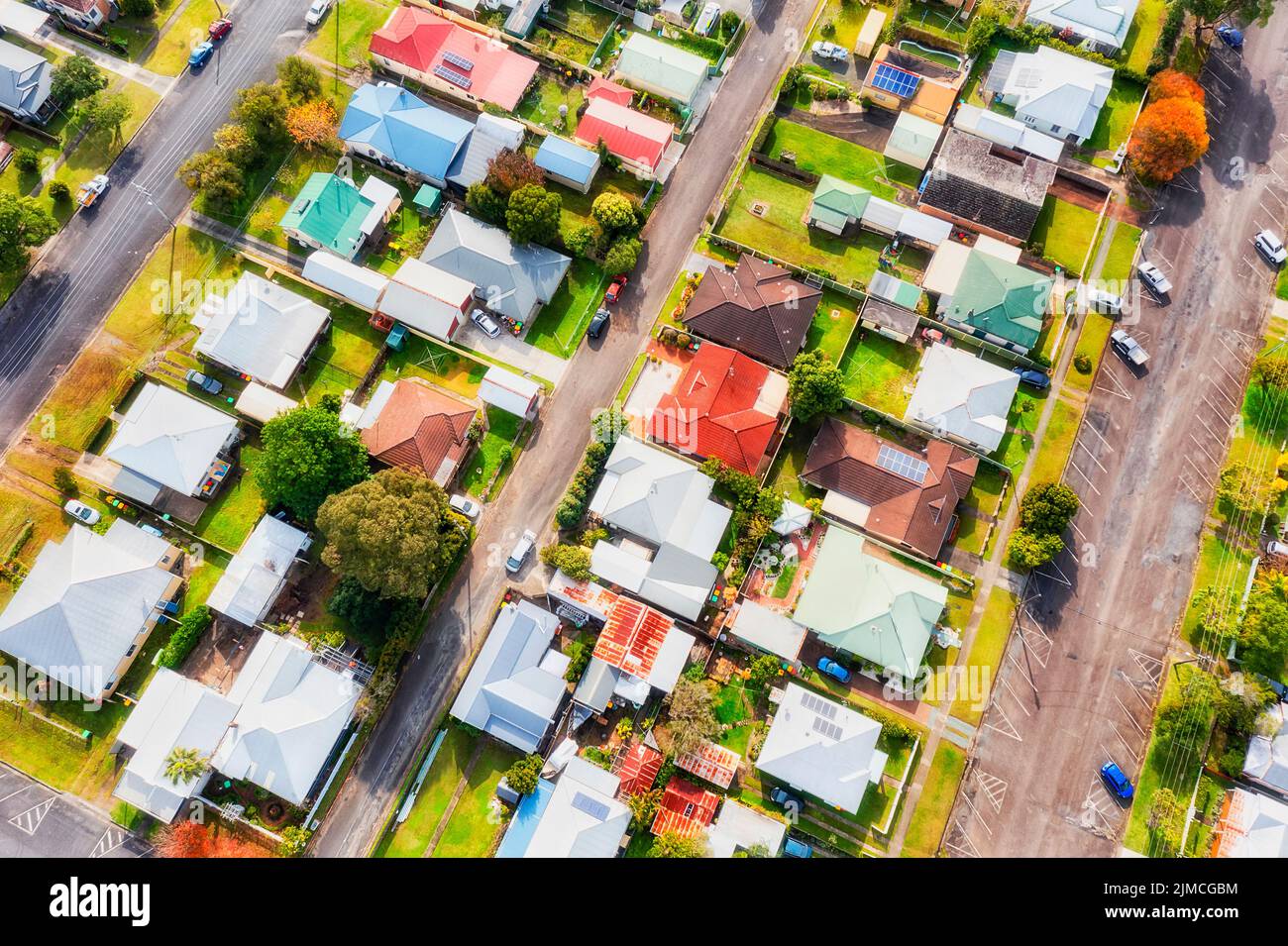 Suburbios con casas independientes independientes en tranquilas calles residenciales en la ciudad rural regional de Australia - vista de arriba hacia abajo aérea. Foto de stock