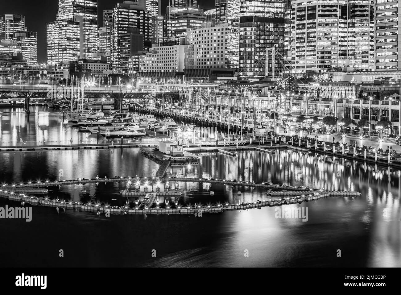 Vista panorámica del puerto Darling Harbour de alto contraste negro blanco en el distrito central de negocios de la ciudad de sídney al atardecer con una fuente de agua flotando en la bahía Coodle. Foto de stock