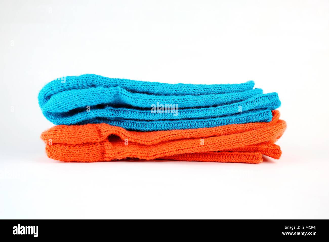 Calcetines de tejido de lana aislados sobre fondo blanco en naranja y azul Foto de stock
