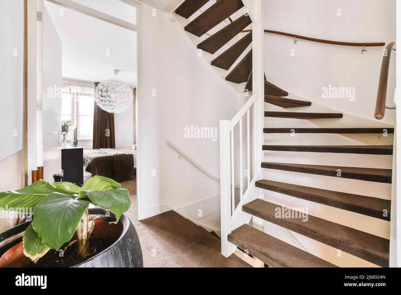 Interior de una casa con escaleras a un piso superior en un ambiente luminoso Foto de stock