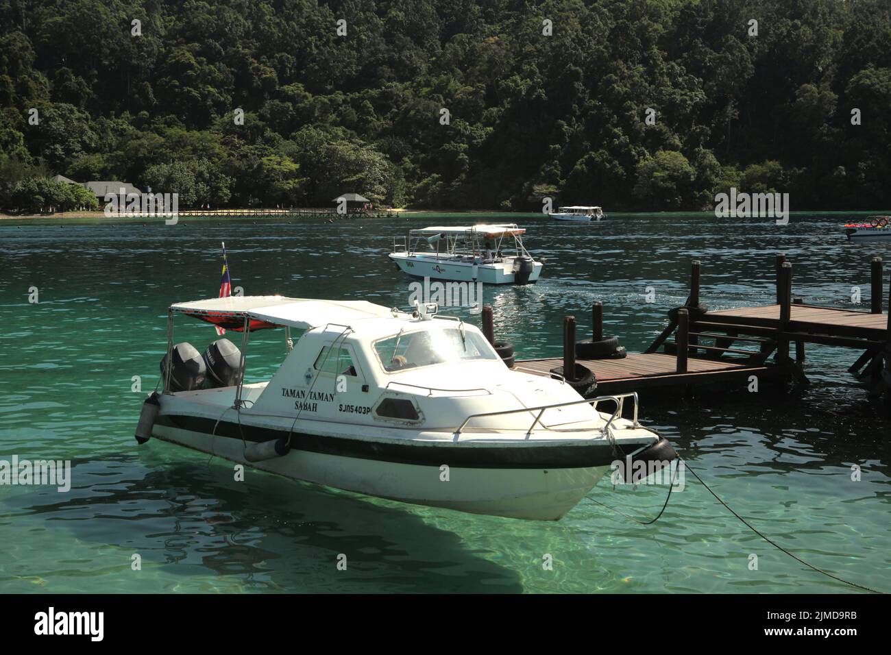 Un barco turístico en las aguas costeras de Pulau Sapi (isla SAPI), una parte del parque Tunku Abdul Rahman en Sabah, Malasia. Foto de stock