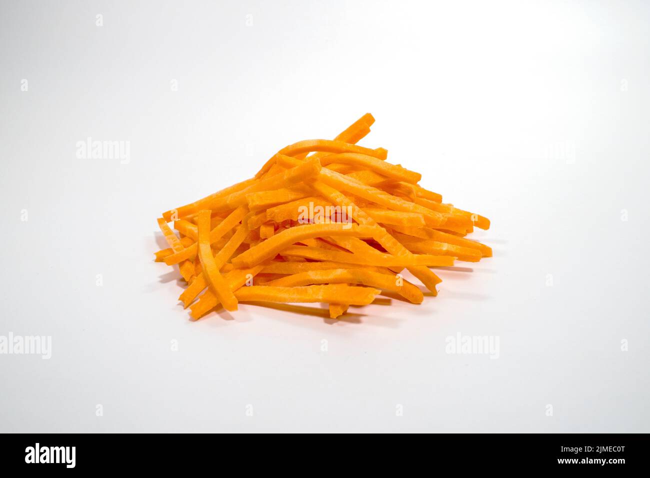Palitos dulces de zanahoria en un montón, aislados sobre fondo blanco Foto de stock