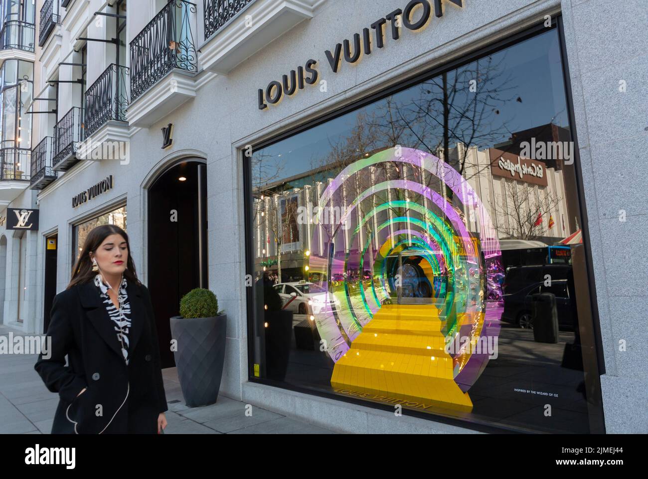 Madrid, España, Escena callejera, Mujer caminando fuera de Louis Vuitton, Frente de tienda LVMH, Signo, Marca, Edificio, Centro de la ciudad Foto de stock