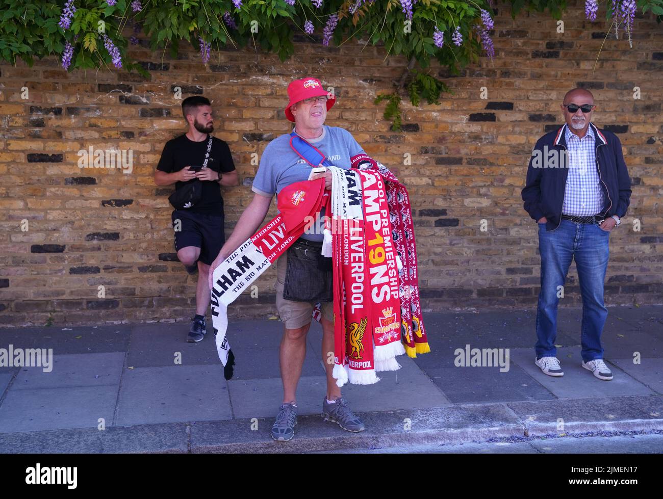 Un vendedor de bufandas fuera del suelo antes del partido de la Premier League en Craven Cottage, Londres. Fecha de la foto: Sábado 6 de agosto de 2022. Foto de stock