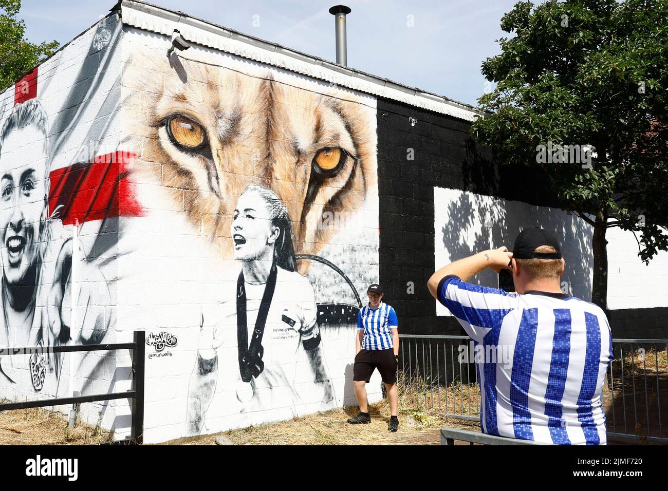 Una persona tiene una foto tomada delante de un mural de Leah Williamson de Inglaterra en Newport Pagnell después de que Inglaterra ganó la Eurocopa 2022 de las Mujeres, Newport Pagnell, Gran Bretaña, 6 de agosto de 2022 Action Images via Reuters/Andrew Boyers Foto de stock