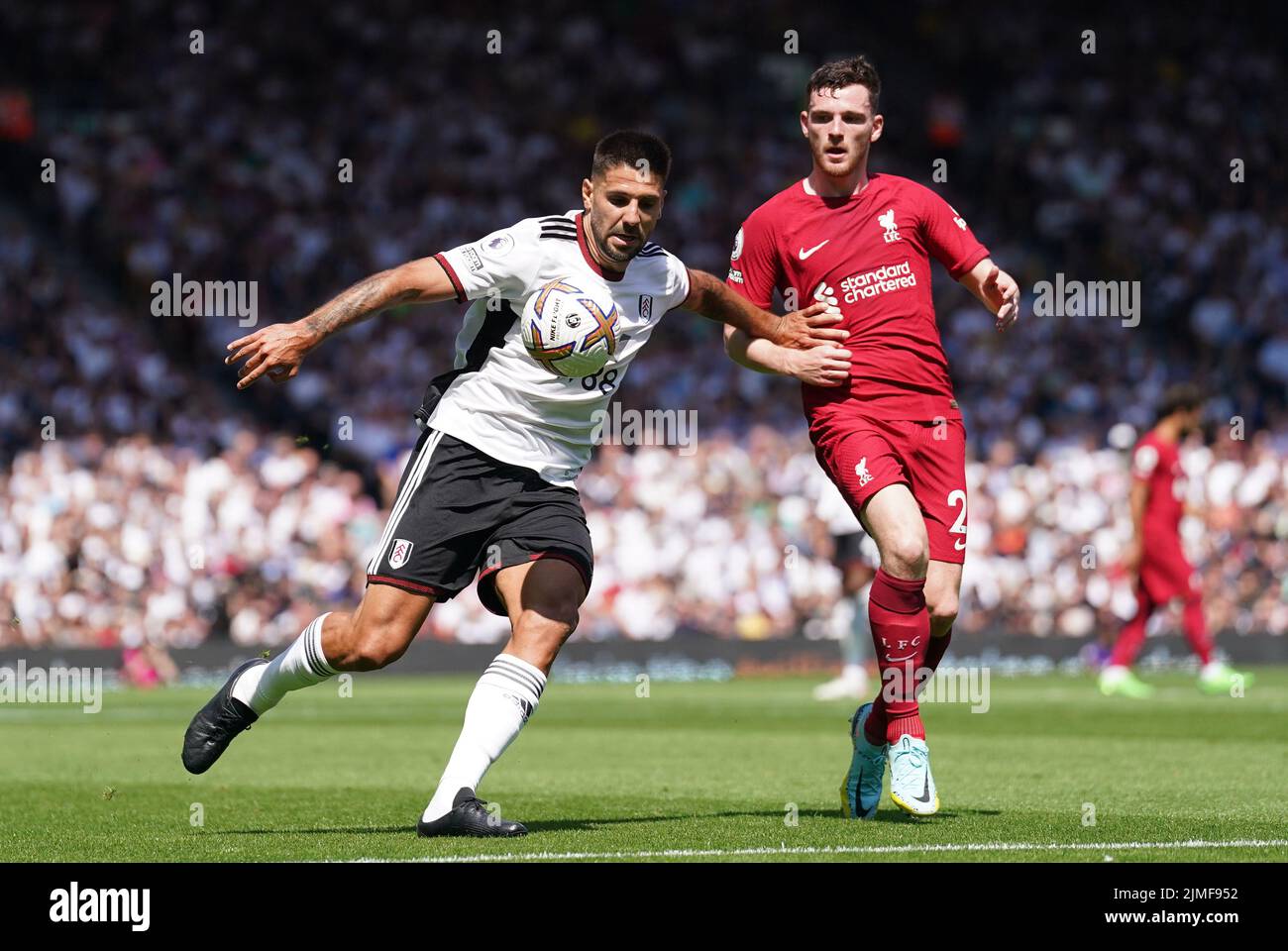 Aleksandar Mitrovic de Fulham (izquierda) y Andrew Robertson de Liverpool luchan por el balón durante el partido de la Premier League en Craven Cottage, Londres. Fecha de la foto: Sábado 6 de agosto de 2022. Foto de stock