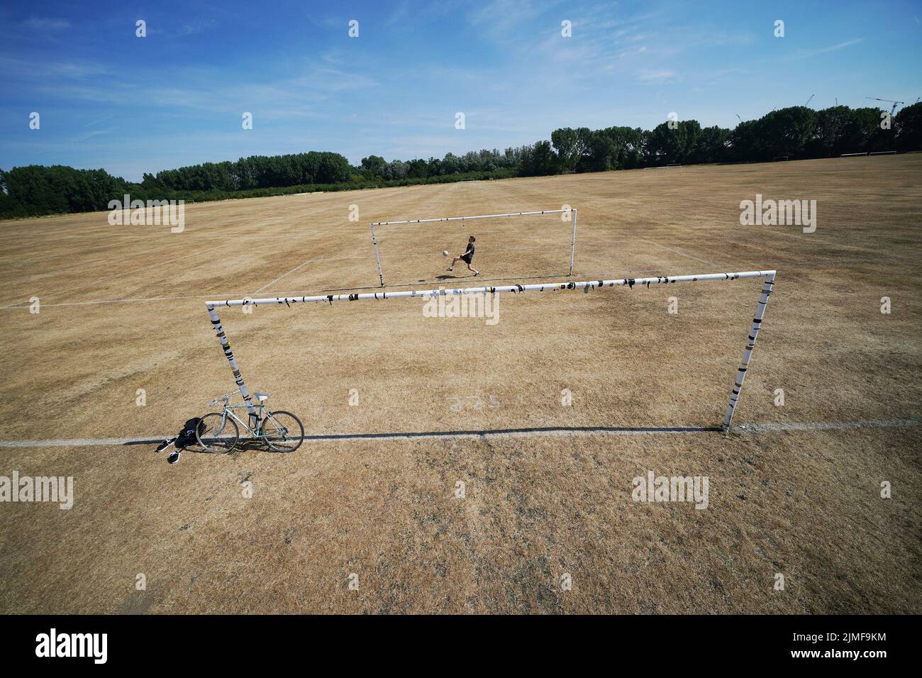 Andy Needle patea un balón de fútbol en los campos cerrados de Hackney Marshes, al este de Londres. Fecha de la foto: Sábado 6 de agosto de 2022. Foto de stock