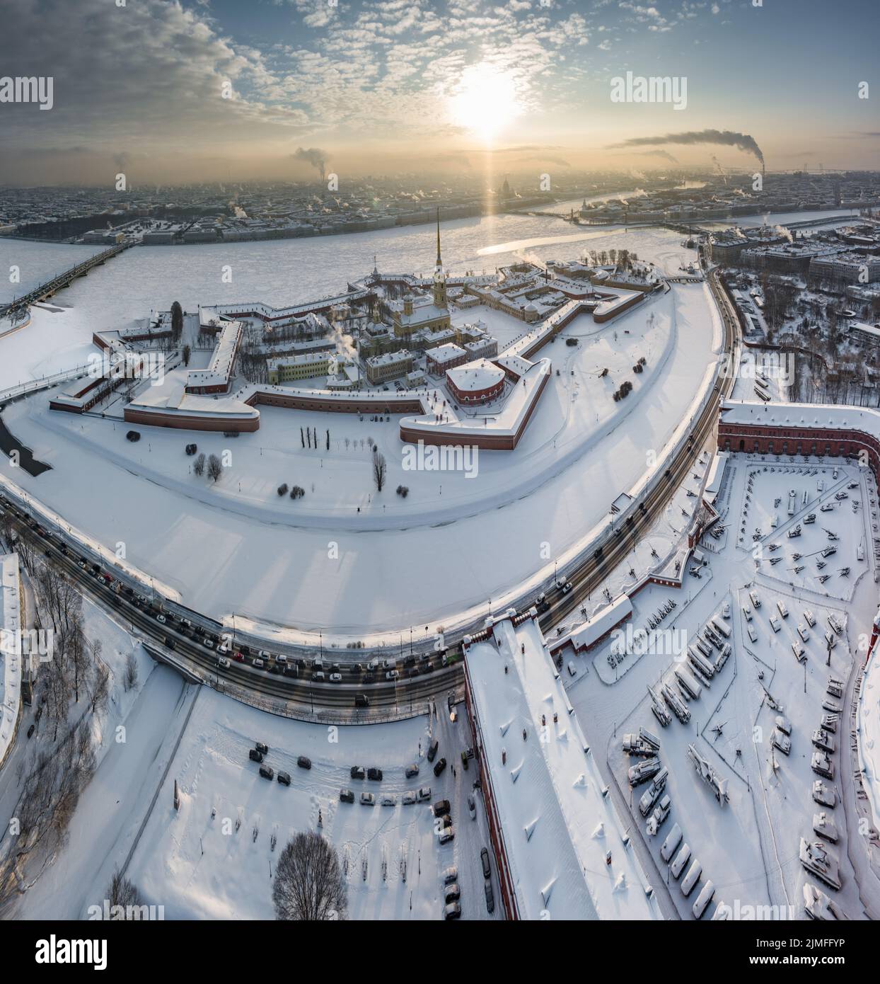 Punto de vista del invierno San Petersburgo al atardecer, río Neva congelado, vapor sobre la ciudad, fortaleza de Pedro y Pablo, tráfico de coches Foto de stock