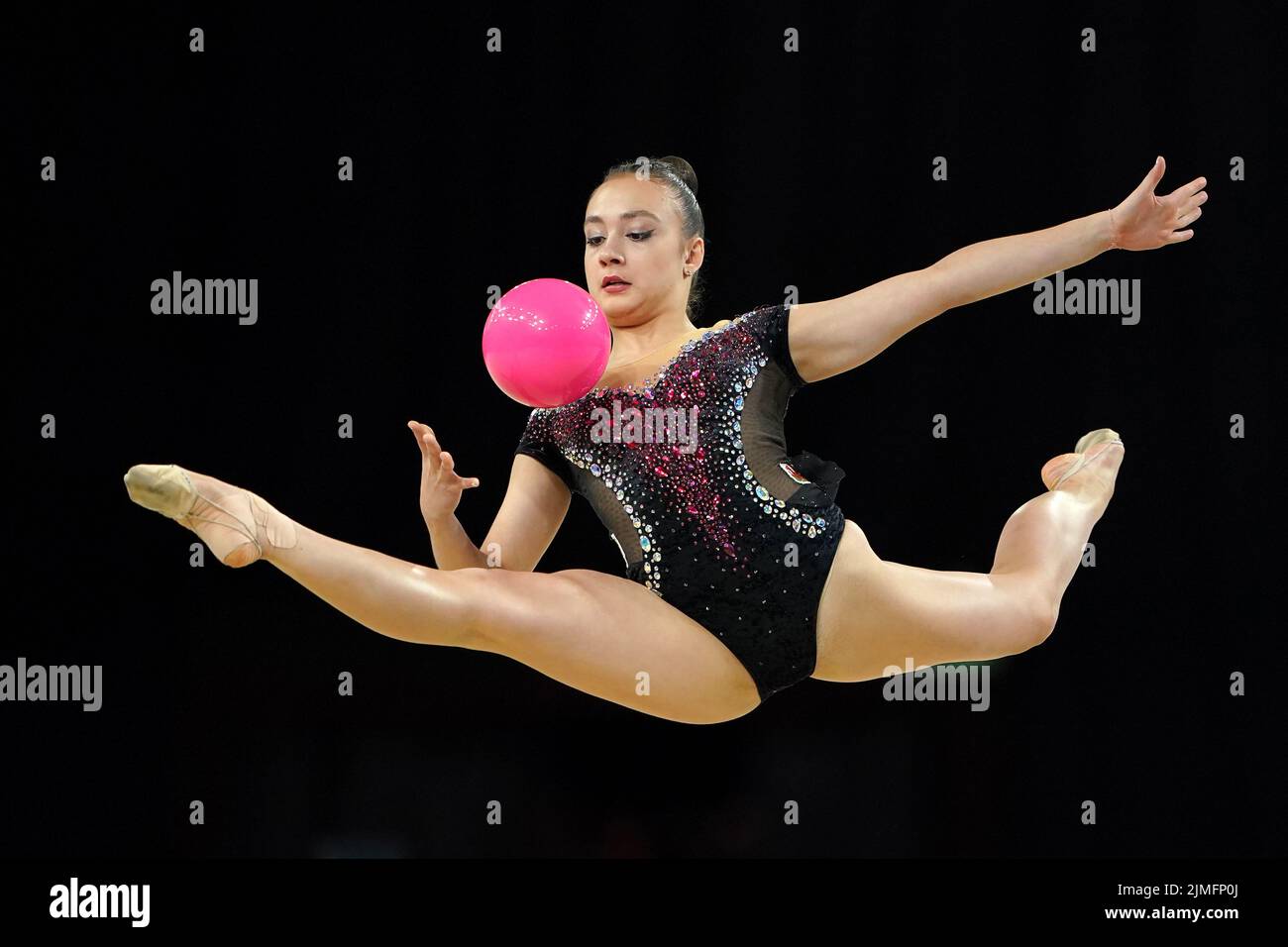 Un grupo de niñas preadolescentes vistiendo leotards espumoso rosado,  haciendo gimnasia rítmica con cinta de arte en la escuela sala de deportes  Fotografía de stock - Alamy