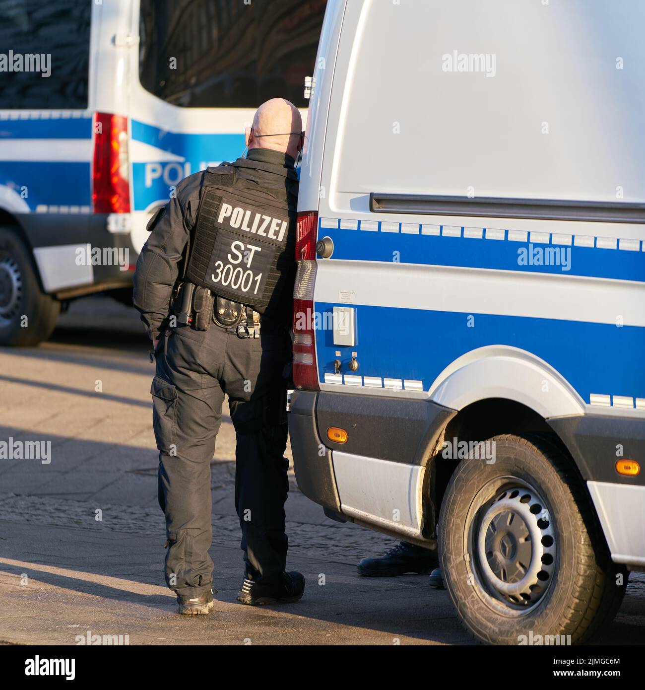 Oficial de policía en el margen de una manifestación en Alemania en toma un descanso y se aburre Foto de stock