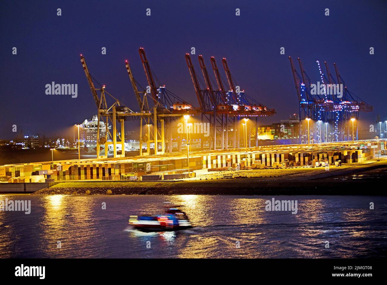 Grúas de carga en la terminal de contenedores de Tollerort por la noche, puerto de Hamburgo, Alemania Foto de stock