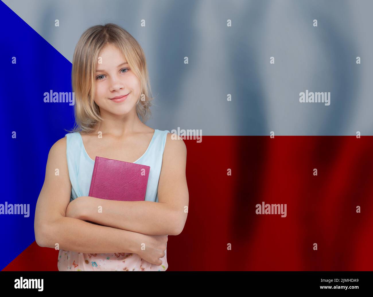 Chica joven joven rubia adolescente con libro contra el fondo de la bandera checa. Educación y escuela en la República Checa Concepto Foto de stock