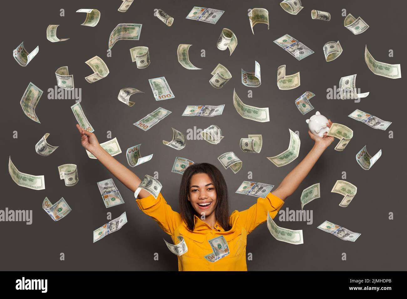Retrato de una joven feliz echando billetes de banco aislados sobre fondo blanco Foto de stock