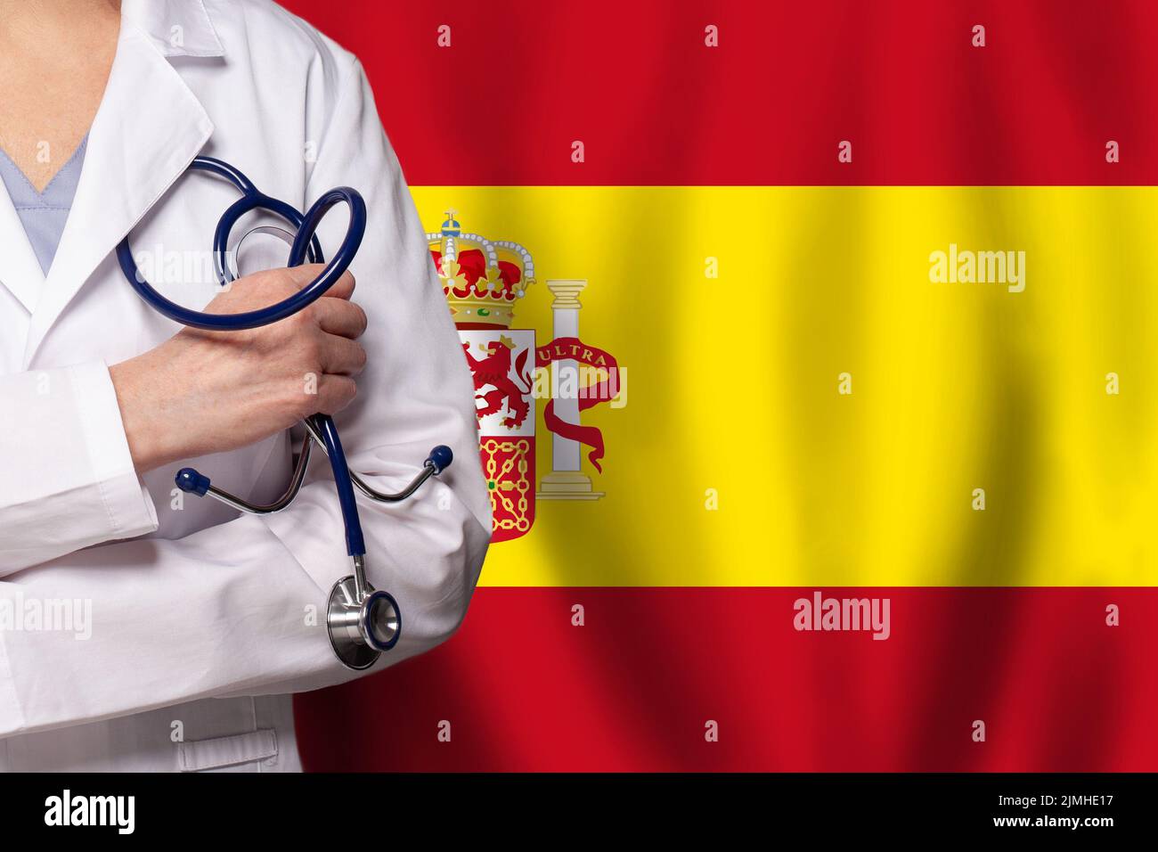 Concepto español de medicina y asistencia sanitaria. Médico de cerca contra bandera de España de fondo Foto de stock