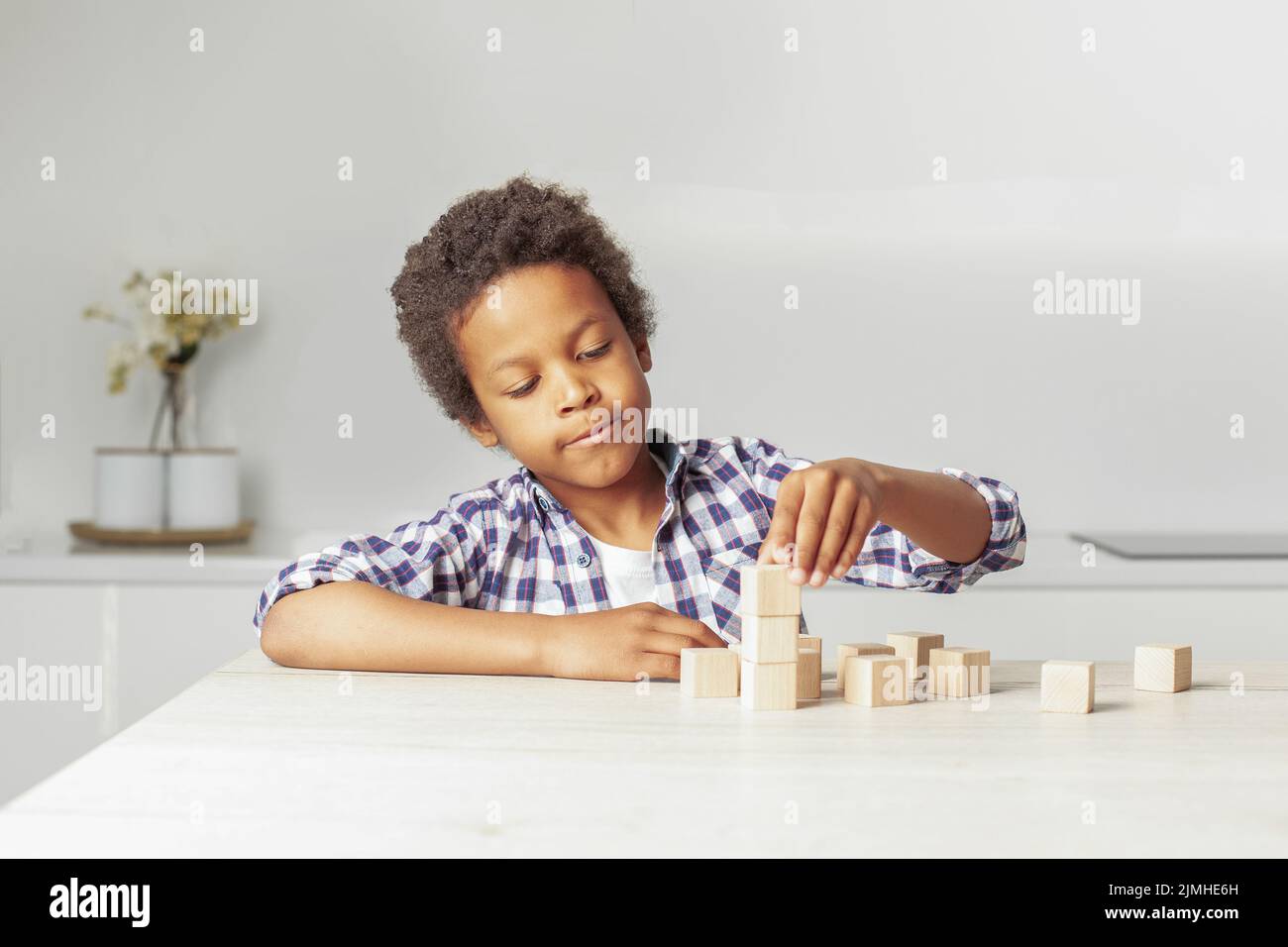 Niño jugando con bloques de madera. Juegos educativos de kindergarten. Foto de stock