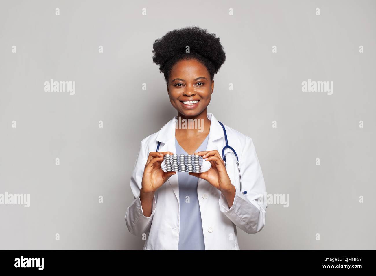 Retrato de una mujer médica inteligente sostiene la tableta de la píldora sobre fondo blanco Foto de stock